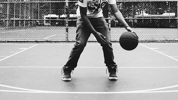player dribbling basketball on outdoor court