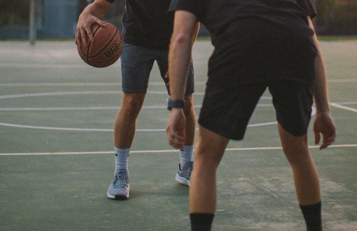 two men playing basketball outdoors