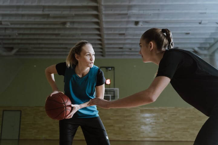 Girls playing basketball in a gym 