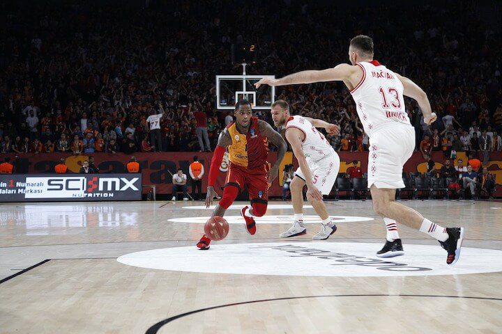 male basketball player drives to the hoop near the restricted area